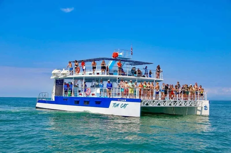 Catamaran sailing along Manuel Antonio coastline with snorkelers preparing to explore coral reefs on an all-inclusive eco adventure tour Costa Rica